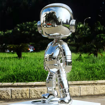 La decorazione domestica dell'interno scolpisce la scultura dello specchio di acciaio inossidabile del ragazzo del robot
